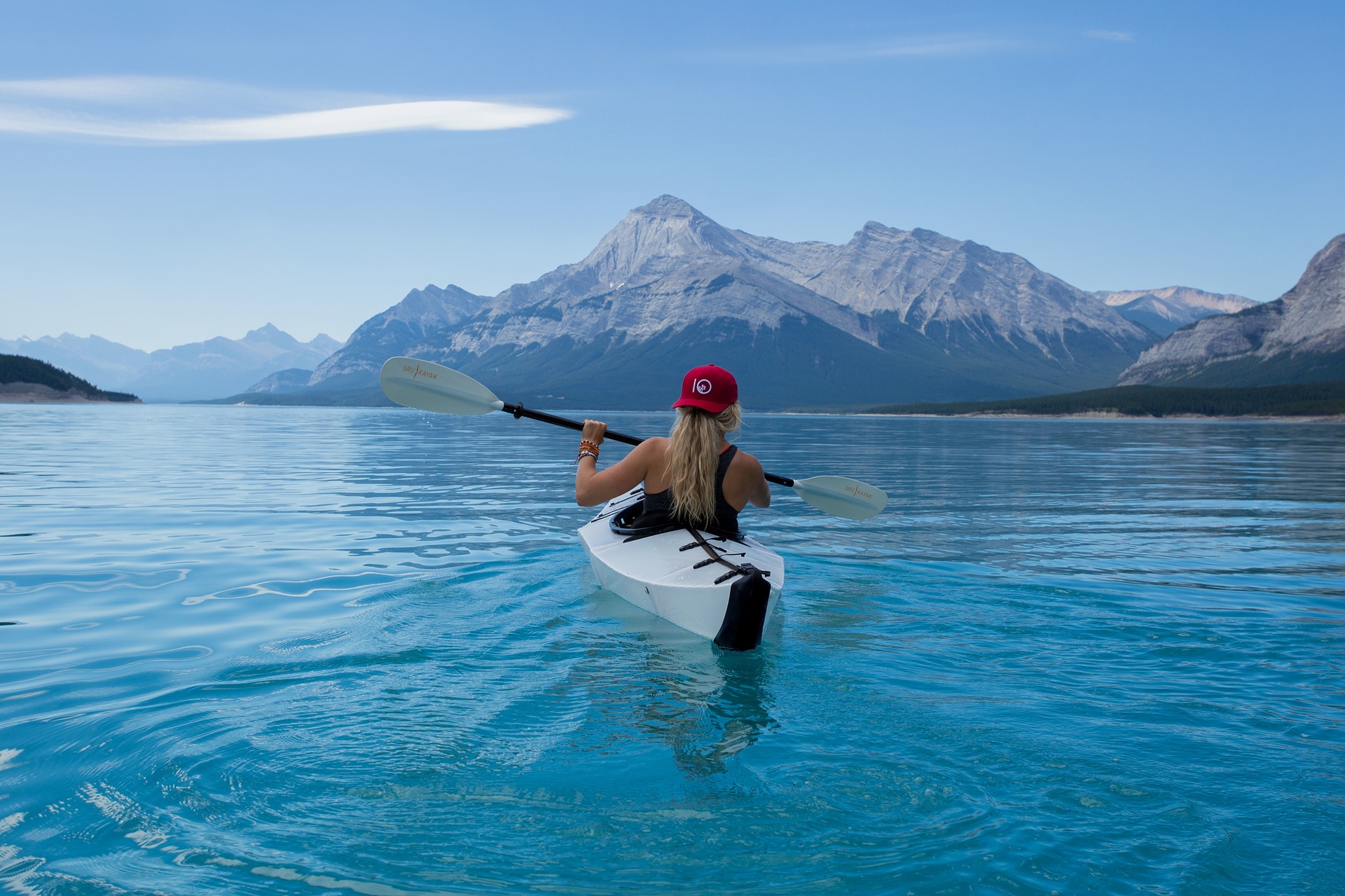 Image: girl paddling in scenic lake with mountains 