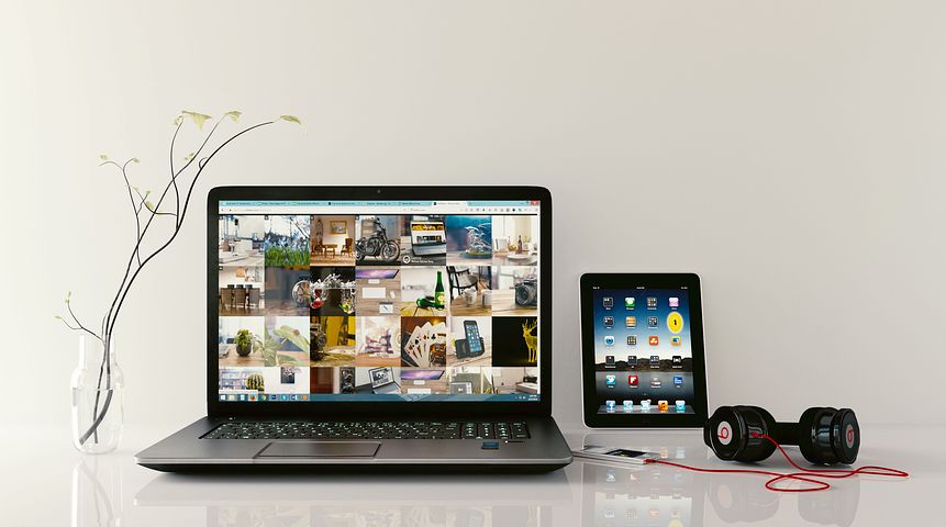 image: laptop tablet headphones on table