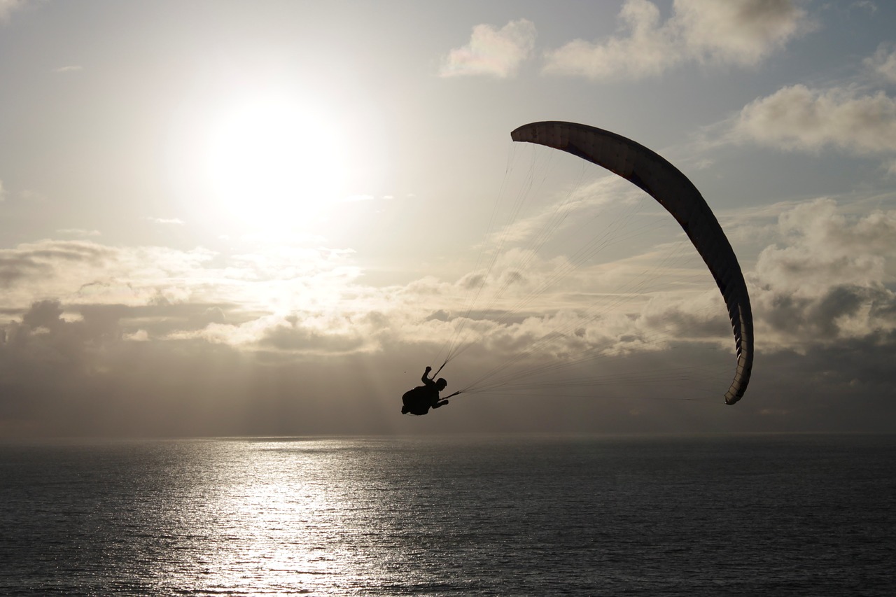 image: paragliding over sparkling water sunrise sunset