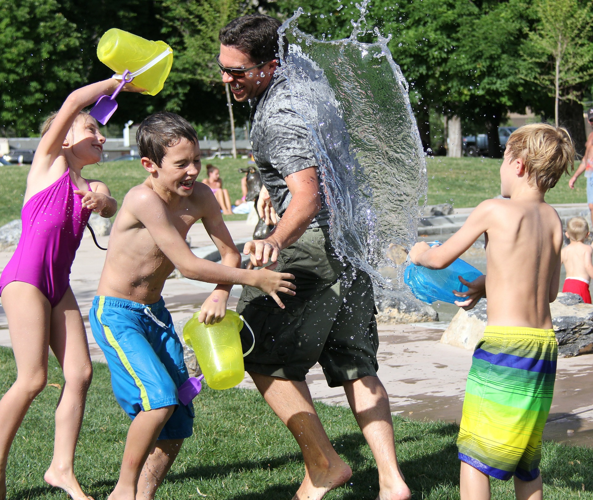 Image: Man and children laughing having a water fight